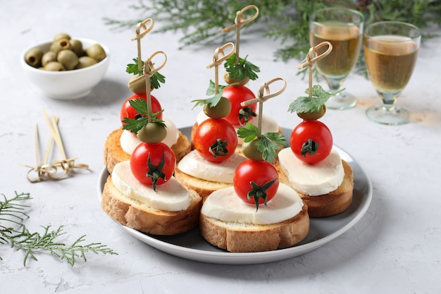 Canapés de mozzarella, tomates cerises, olives vertes, persil sur croûtons de pain blanc