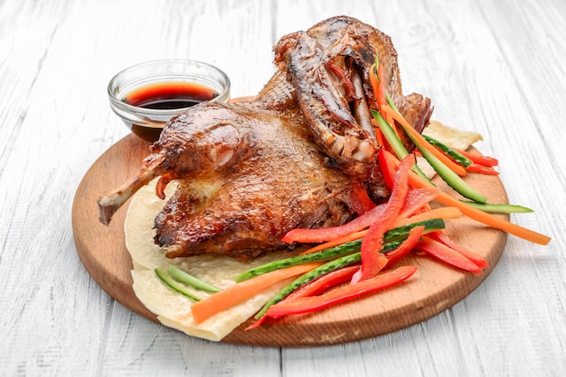 Photo canard au four avec des légumes sur une surface en bois