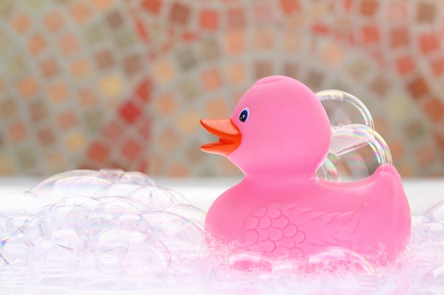 Canard en caoutchouc rose dans un bain moussant
