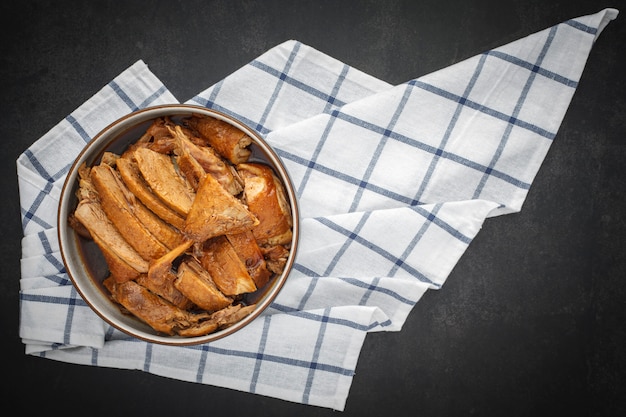Canard cuit chinois brun savoureux dans un bol avec serviette de table