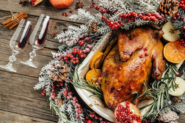 Canard entier cuit au four avec du romarin et des oranges sur une table en bois rustique Canard de Pékin farci de Noël rôti traditionnel