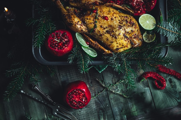 Canard de Noël aux grenades et au citron vert entouré d'une branche d'épinette