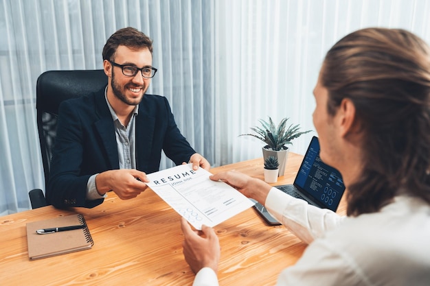 Le candidat remet son curriculum vitae ou son CV sur la table à l'intervieweur