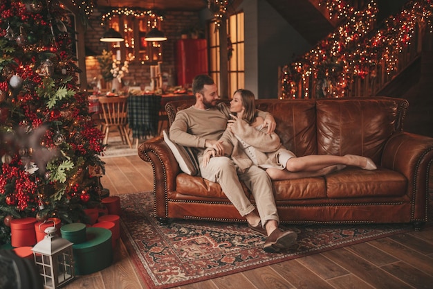 Candide authentique couple marié heureux passer du temps ensemble au pavillon en bois décoré de Noël