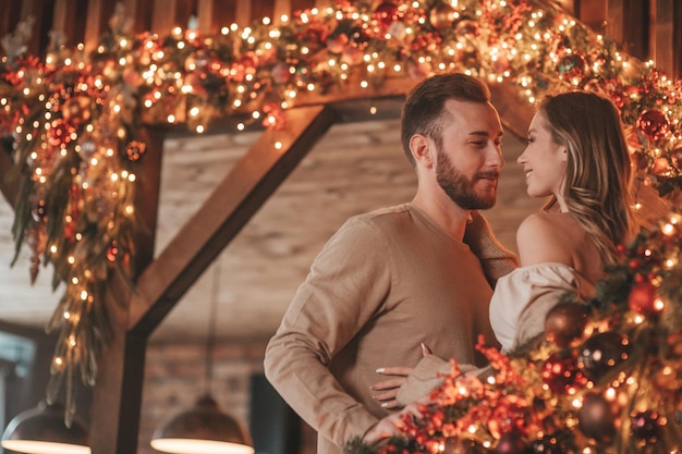 Candide authentique couple marié heureux passer du temps ensemble au pavillon en bois décoré de Noël