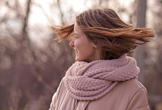 Candide séduisante jeune femme souriante marchant dans le parc d'automne bonne humeur mode style tendance veste rose agitant les cheveux bruns