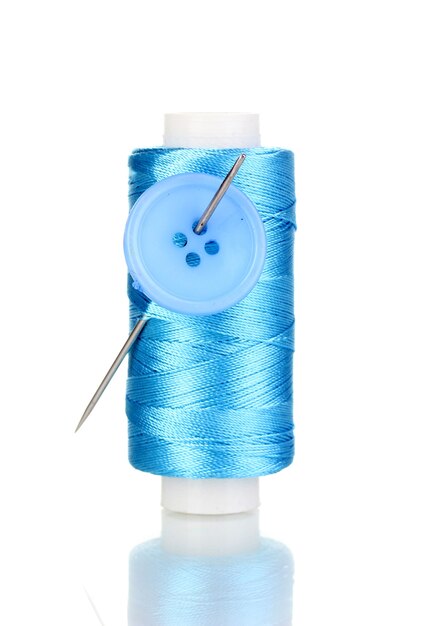 Canette bleue avec aiguille et boutons sur blanc