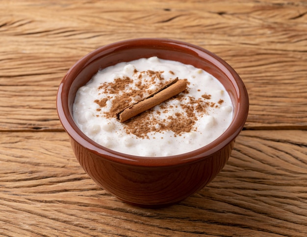 Canjica ou munguza crème sucrée de maïs blanc brésilien typique à la cannelle sur table en bois