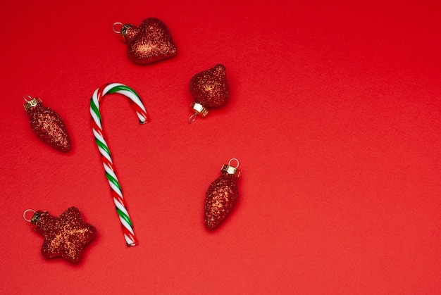 Canne de Noël et décorations d'arbre de Noël sur fond rouge