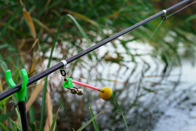 Canne à pêche au bord de la rivière. attraper du poisson au lever du soleil