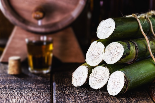 canne à sucre utilisée dans les boissons distillées, fond de baril et verre avec boisson alcoolisée