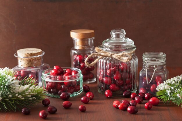 Photo canneberge fraîche dans des bocaux en verre, décoration d'hiver