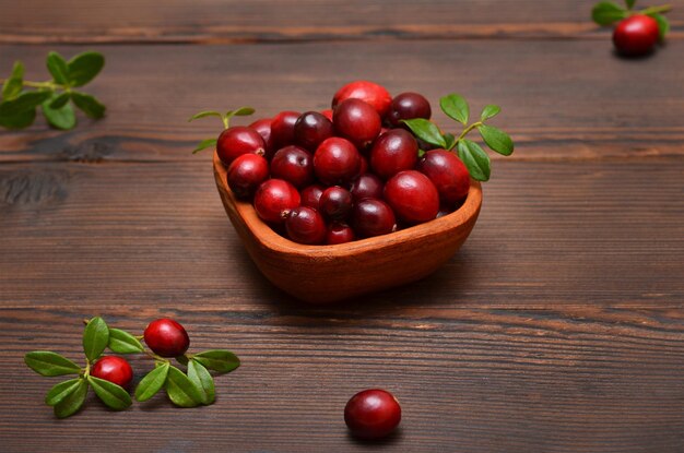 des canneberges rouges dans un bol en bois sur la table