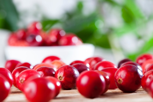 Canneberges saines aigres rouges entières, canneberges entières mûres rouges sur la table, canneberges maison cultivées dans un jardin industriel