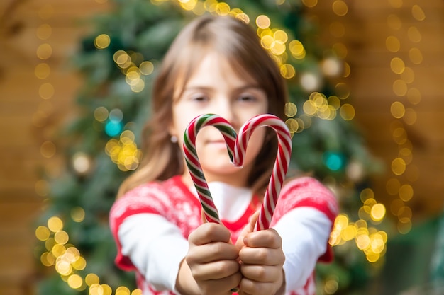 Cannes de bonbon de Noël dans les mains d'un enfant. Mise au point sélective. Vacance.