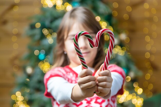 Cannes de bonbon de Noël dans les mains d'un enfant. Mise au point sélective. Vacance.