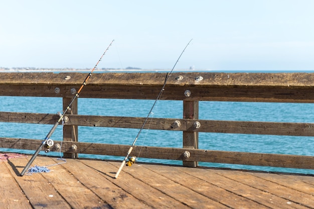 Cannes à pêche s'appuyant sur un rail sur une jetée à Ventura Los Angeles en Californie