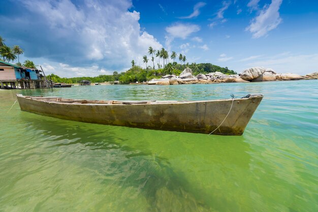 canoë sur la plage à l'eau claire avec des cocotiers en arrière-plan