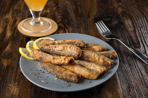 Capelan frit dans une assiette sur une table en bois