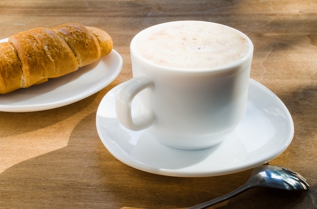 Photo cappuccino ou café au lait et croissant.