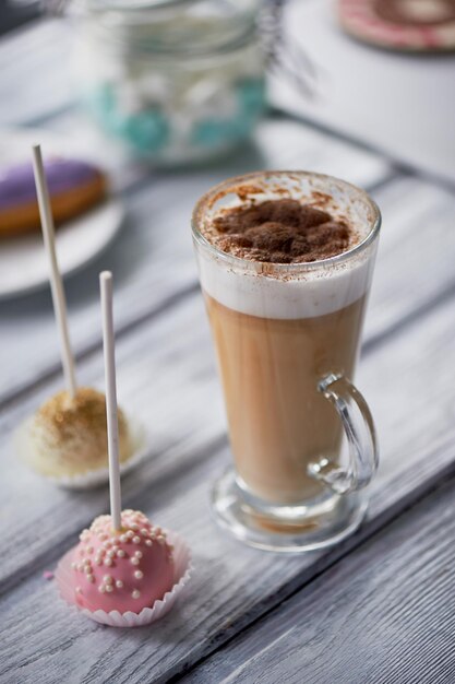 Cappuccino de café avec de beaux bonbons sur fond de bois Beaux bonbons