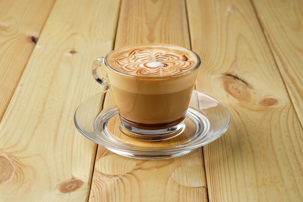 Cappuccino dans une tasse en verre transparent sur une table en bois