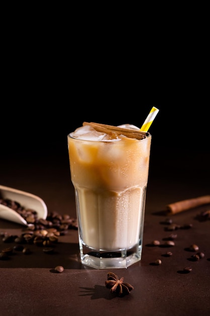 Cappuccino avec des glaçons dans un grand verre sur fond noir Café glacé au lait