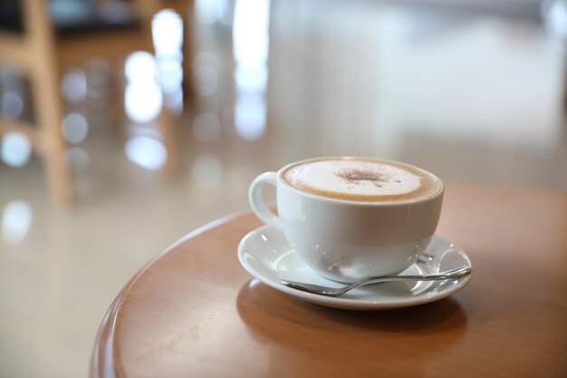 Cappuccino ou Latte art café à base de lait sur la table en bois du café