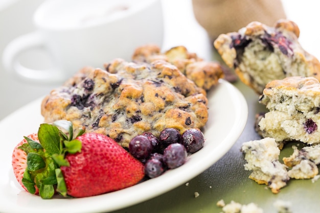 Photo cappuccino avec scone aux myrtilles fraîches pour le petit-déjeuner.