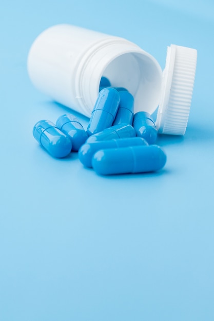 Capsules bleues, pilules sur fond bleu