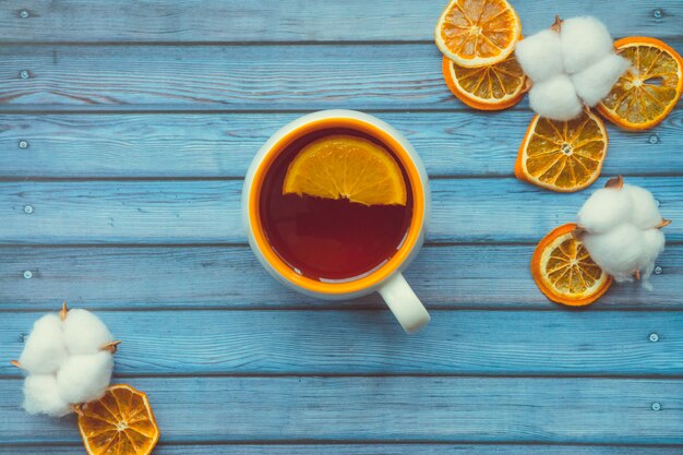 Capsules De Coton Et Tasse De Thé Chaud Avec Orange Sur Une Table En Bois Bleue