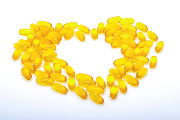 Capsules d&#39;huile de poisson jaune en forme de coeur