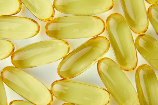 Capsules d'huile de poisson à plat Omega 3 isolées sur fond blanc concept de soins de santé espace de copie maco