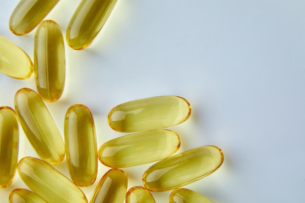 Capsules d'huile de poisson à plat Omega 3 isolées sur fond blanc, concept de soins de santé, maco, espace de copie.