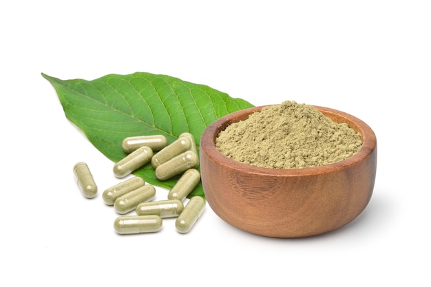 Capsules de Kratom (Mitragyna speciosa) avec poudre et feuille verte isolées sur une surface blanche