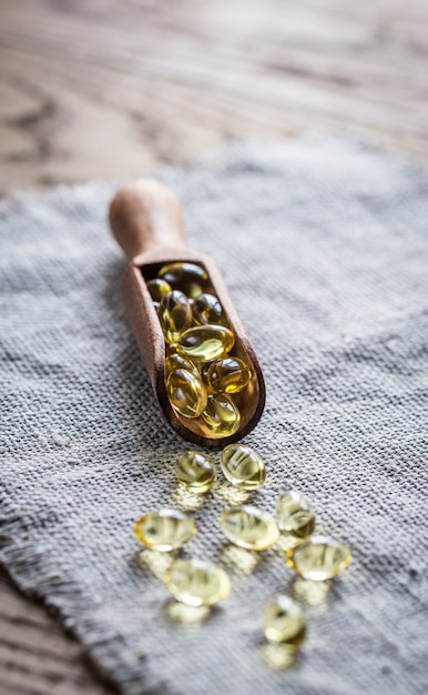 Capsules d'oméga-3 dans la cuillère en bois