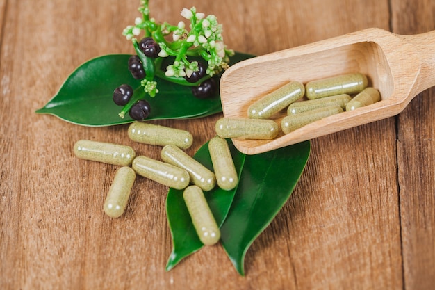 Capsules de phytothérapie d&#39;herbe sur une table en bois rustique