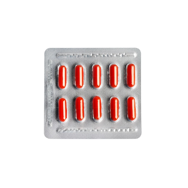 Capsules de pilule rouge sous blister isolé sur blanc