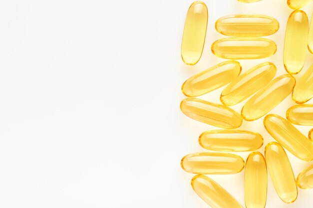 Capsules Pilules jaunes isolées sur blanc Capsules Close Up avec vitamine D E ou acides gras oméga 369 Suppléments alimentaires remplis d'huile d'huile de poisson Suppléments naturels pour un concept de vie saine et saine Bannière