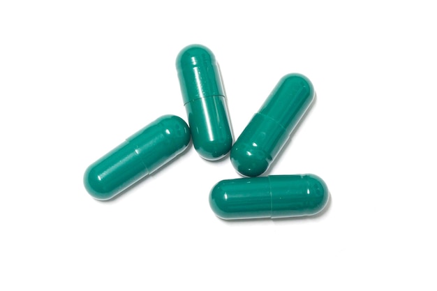 Capsules de pilules vertes sur fond blanc