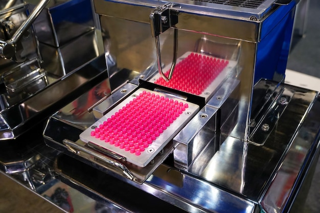 Capsules roses et blanches pilules dans la machine d'emballage de pilules pilule de capsule de médicament de pharmacie dans la ligne de production d'une usine médicale