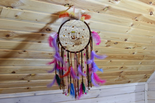 Photo capteur de rêves fait main coloré. amulette traditionnelle des anciens indiens des mauvais esprits. amulette tressée avec des plumes