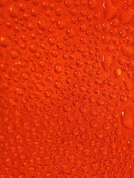 Photo capture complète de gouttes d'eau sur une surface orange