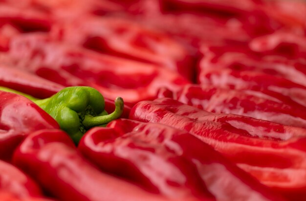 Photo capture complète d'un piment vert arrondi par des piments rouges