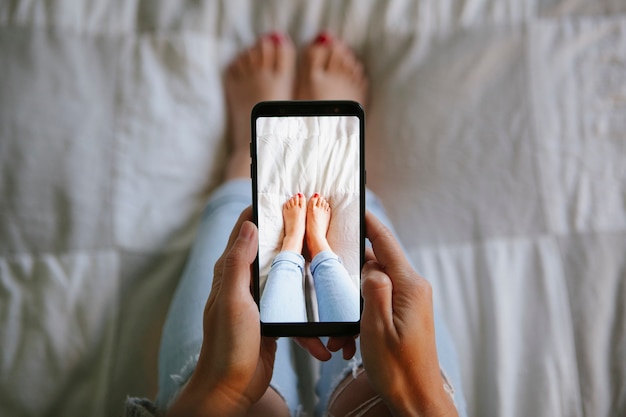 Capture d'écran d'une femme aux pieds avec le téléphone