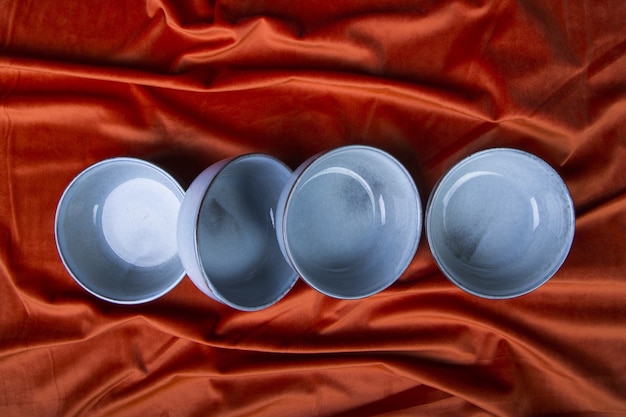 Capture en grand angle de bols bleus sur un textile orange