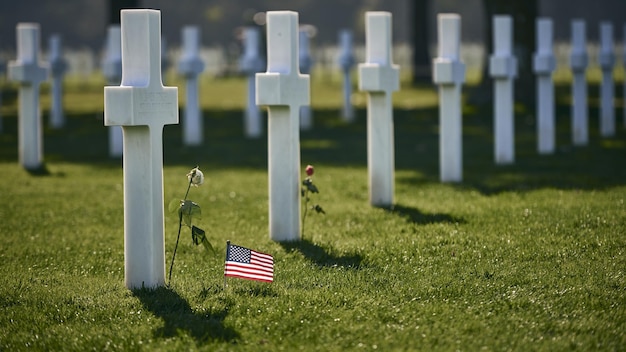 Capture horizontale d'un cimetière militaire avec des pierres tombales en croix blanche et un drapeau des États-Unis