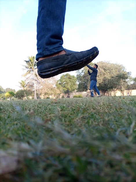 Photo une capture mobile dans laquelle d'énormes pieds de chaussures noires dans un petit petit garçon qui essaie de le sauver lui-même