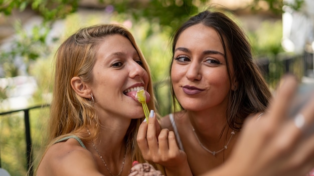 Capture sélective de jeunes filles séduisantes prenant un selfie dans un café