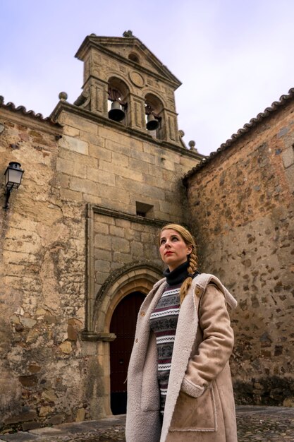 Capture verticale d'une jeune femme blonde voyageant dans un lieu médiéval